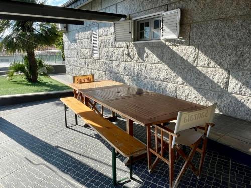 a wooden table and benches in front of a building at Casa da Anta in Chaves
