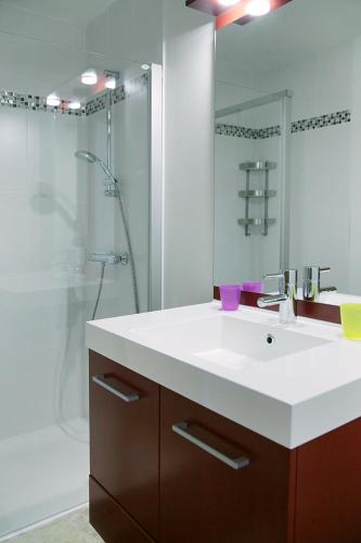 une salle de bain avec un lavabo blanc et une douche dans l'établissement Gîte de Berle, à Chauffour-sur-Vell
