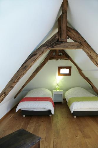 - 2 lits dans une chambre mansardée dans l'établissement Gîte de Berle, à Chauffour-sur-Vell