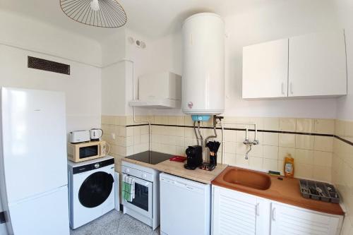 une petite cuisine avec des armoires blanches et un micro-ondes dans l'établissement Apartment with terrace near the sea, à Nice