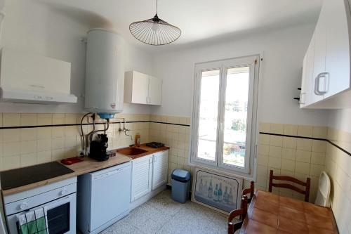 une cuisine avec des armoires blanches et une fenêtre dans l'établissement Apartment with terrace near the sea, à Nice