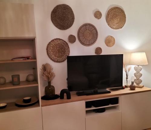 un salon avec une télévision à écran plat sur un mur dans l'établissement Lovely T2 with garden by the sea, à Camiers