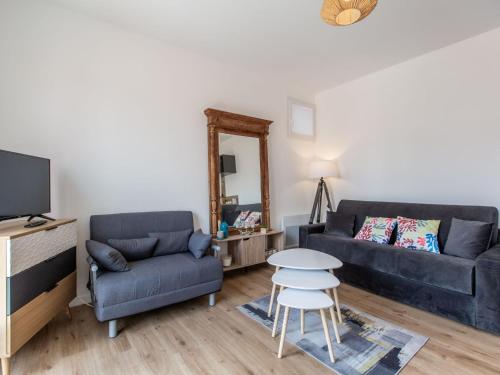 un salon avec deux canapés bleus et une table dans l'établissement Studio Cap Océan-16 by Interhome, à Capbreton