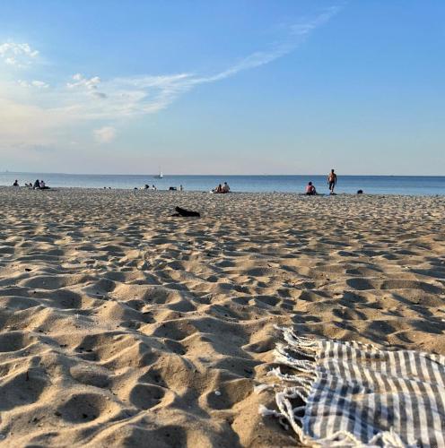 a sandy beach with people on the beach at Agrogajówka in Gniewino