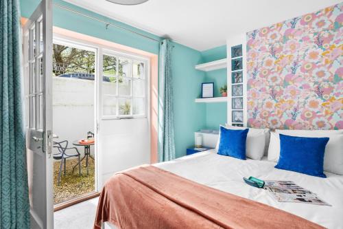 una camera da letto con un letto con pareti blu e una finestra di Harbour Court Plymouth - Free Parking - tucked away on the Barbican with courtyard - by Ocean City Retreats a Plymouth