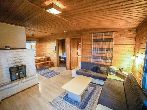 a living room with a couch and a fireplace at Holiday Home Heikkilä by Interhome in Kuusamo