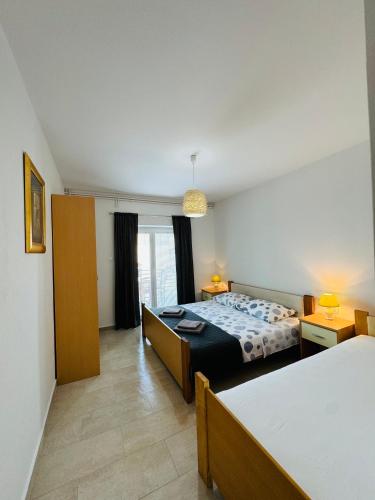 a bedroom with a bed and a room with two beds at Apartment Ivanka in Pag