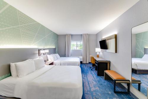 a hotel room with two beds and a television at Comfort Inn & Suites Weston - Wausau in Weston