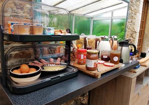 a kitchen counter with food on a counter top at Domaine La Synchronicité - Gîte et Chambres d'Hôtes in Vaudrimesnil
