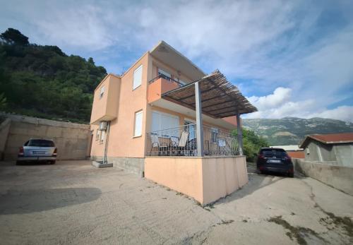 a building with a balcony with cars parked in front of it at Apartmani Seaview in Sutomore