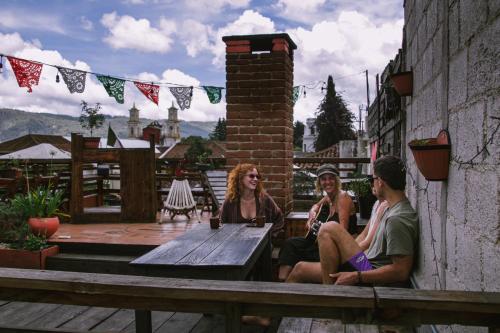 three people sitting on a table on a patio at Casa Satoshi in San Cristóbal de Las Casas