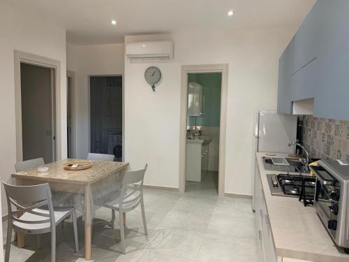 eine Küche mit Tisch und Stühlen und eine Küche mit Uhr in der Unterkunft Il giglio di mare in Santa Maria di Castellabate