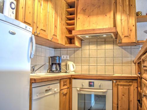 une cuisine avec des armoires en bois et un réfrigérateur blanc dans l'établissement Charmant appartement au cœur de Morzine, proche télécabines, 2 chambres, balcon, parking, WiFi inclus - FR-1-524-40, à Morzine