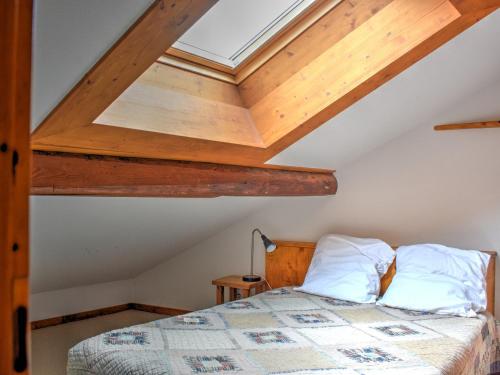 une chambre avec un lit et une lucarne dans l'établissement Charmant appartement au cœur de Morzine, proche télécabines, 2 chambres, balcon, parking, WiFi inclus - FR-1-524-40, à Morzine
