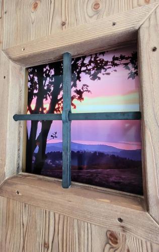 a window in a wooden wall with a cross at Alloggio Conca Dei Parpari in Rovere Veronese