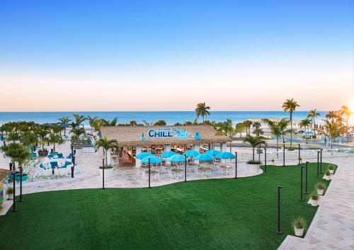 an aerial view of a resort with blue umbrellas and the ocean at Margaritaville Beach Resort Ft Myers Beach in Fort Myers Beach