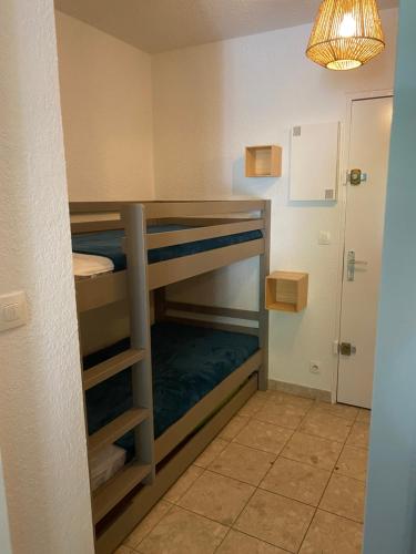 Cette chambre lumineuse comprend des lits superposés. dans l'établissement Appartement 4 personnes avec terrasse et piscine proche plage et commerces, à La Grande Motte