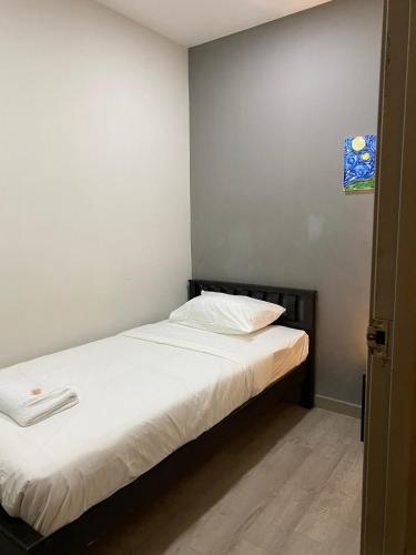 a small bedroom with a bed with white sheets at Aayu Muntri - 4 mins to Chulia St George Town in George Town