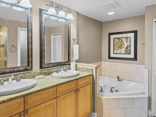 un bagno con due lavandini e una vasca di Azure #404 Luxurious 4BD Beachfront Condo a Fort Walton Beach