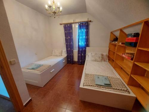 a small room with two beds and a shelf at Villa con Jacuzzi exterior y Piscina cubiertos in Los Ángeles de San Rafael