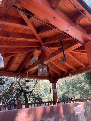 a wooden pavilion with a wooden roof with a light at Villa con Jacuzzi exterior y Piscina cubiertos in Los Ángeles de San Rafael