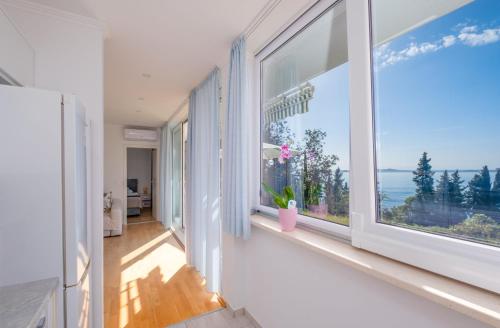 a room with a large window with a view of the ocean at Apartments Katica in Mlini