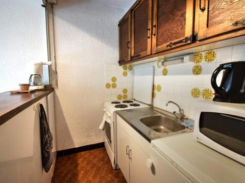 une petite cuisine avec un évier et une cuisinière dans l'établissement Studio 4 pers à 500m du centre de Morzine avec vue, Wifi et parking - FR-1-524-80, à Morzine