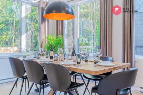 una sala da pranzo con tavolo e sedie e una grande finestra di The Blue Pearl of Portneuf - Private hot tub Pool Trails Billiards a Pont-Rouge