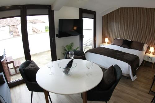 a hotel room with a bed and a table and chairs at Tierra de Lemos- Apartamentos Turísticos in Monforte de Lemos