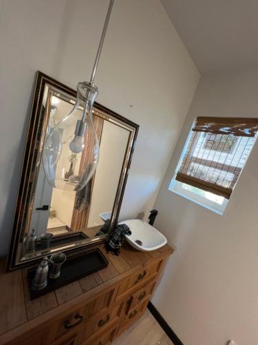 a bathroom with a mirror and a sink on a dresser at Sweet Hill top Townhouse in Prescott
