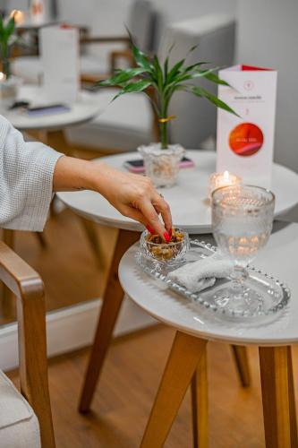 a person reaching for a bowl of food on a table at Grand Mercure Curitiba Rayon in Curitiba