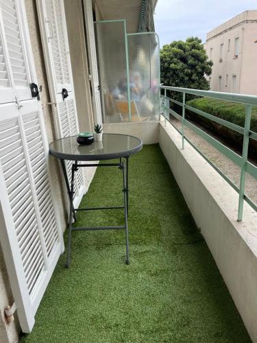 - une table sur un balcon avec de l'herbe verte dans l'établissement 50m2 Climatisé Proche Mer, à Nice