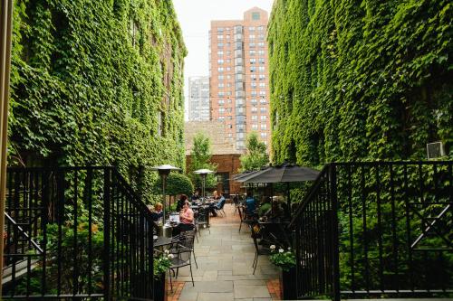 a patio with people sitting at tables in a garden at The Plaza Hotel - Milwaukee in Milwaukee