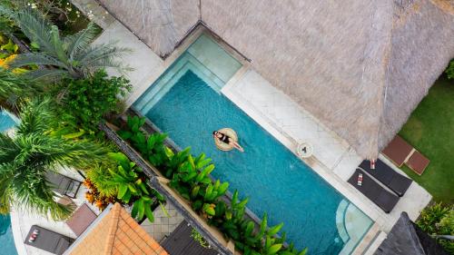 an overhead view of a person swimming in a swimming pool at The Maya Seminyak Villas in Seminyak