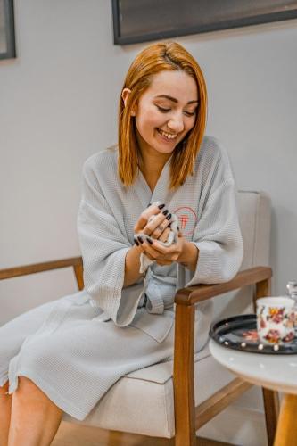 a woman sitting in a chair holding a doll at Grand Mercure Curitiba Rayon in Curitiba