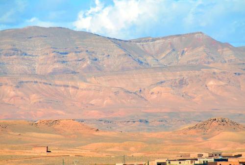a mountain in the middle of a desert with houses at Sud Est Palace in Aït Ridi