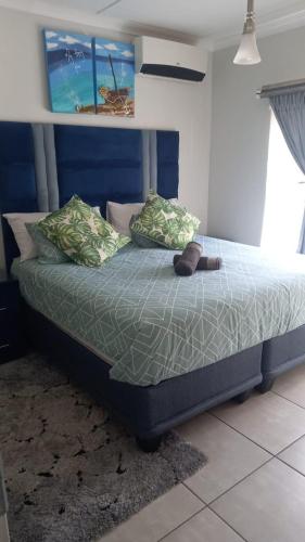 a bed with two pillows and a footboard with a shoe on it at 521 at The Blyde in Pretoria