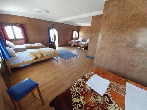 a living room with two beds and a couch at Sud Est Palace in Aït Ridi