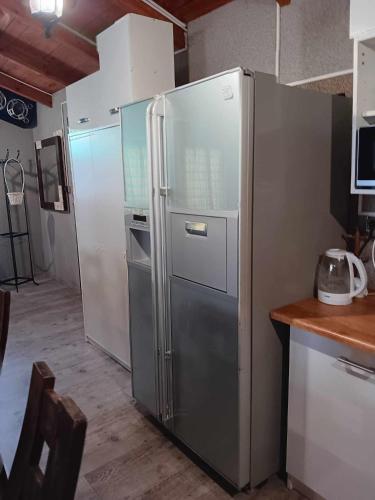 a kitchen with a stainless steel refrigerator in a kitchen at Chata na Rogu in Boszkowo-Letnisko