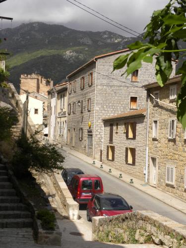 Deux voitures garées sur le côté d'une rue avec des bâtiments dans l'établissement Olmeto 10 mn plage App 5-6P, à Olmeto