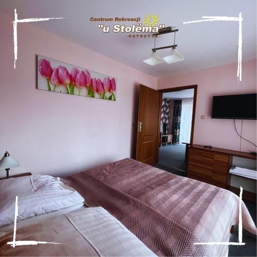a bedroom with a bed and a painting of pink tulips at Centrum Rekreacji U Stolema in Ostrzyce