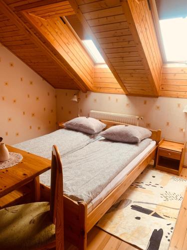 a bedroom with a bed and a wooden ceiling at Agroturystyka nad jeziorem-Herrmann hof in Dejguny