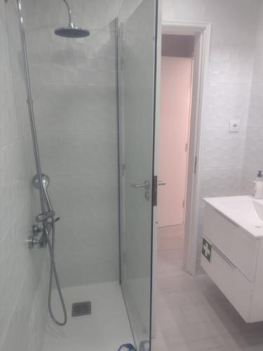 a shower with a glass door in a bathroom at Casinhas de Alfenim in Sesimbra