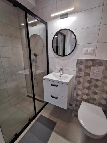 a bathroom with a toilet and a sink and a mirror at Dom gościnny z restauracją - Rejs in Dziwnów