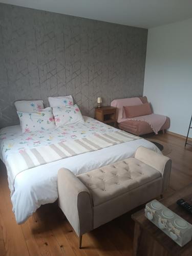 une chambre avec un grand lit blanc et une chaise dans l'établissement Le domaine de Moïse, à La Fouillade