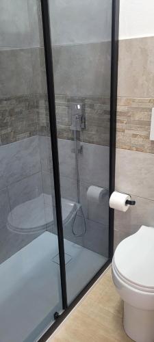 a glass shower in a bathroom with a toilet at Alghero sun in Alghero