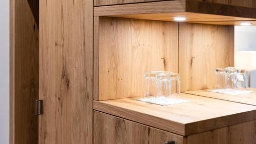 due bicchieri da vino sono seduti su un mobile di legno di Central City Hotel Rochat a Basilea