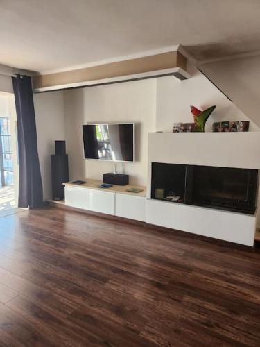 a living room with a large television and a hard wood floor at L'Apt Tropez in Apt