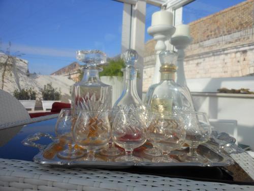 a tray with wine glasses and a bottle on a table at Palazzo Antica Via Appia in Bitonto