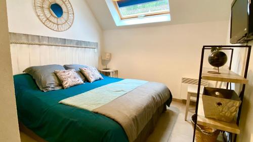 - une chambre avec un lit doté de draps verts et une fenêtre dans l'établissement La Riviera à 50m de la plage, à Bénodet